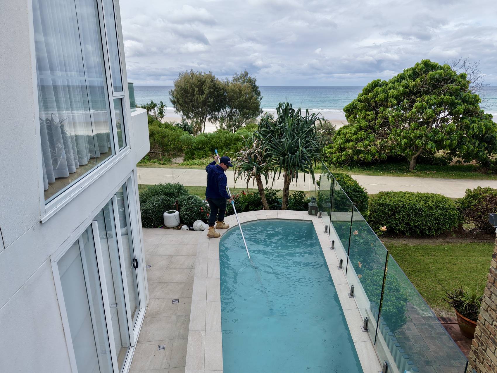 Blue Avenue Pools servicing a canal-front pool on the Gold Coast, ocean directly behind